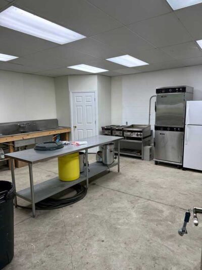 A kitchen with a table , refrigerator , and stove.