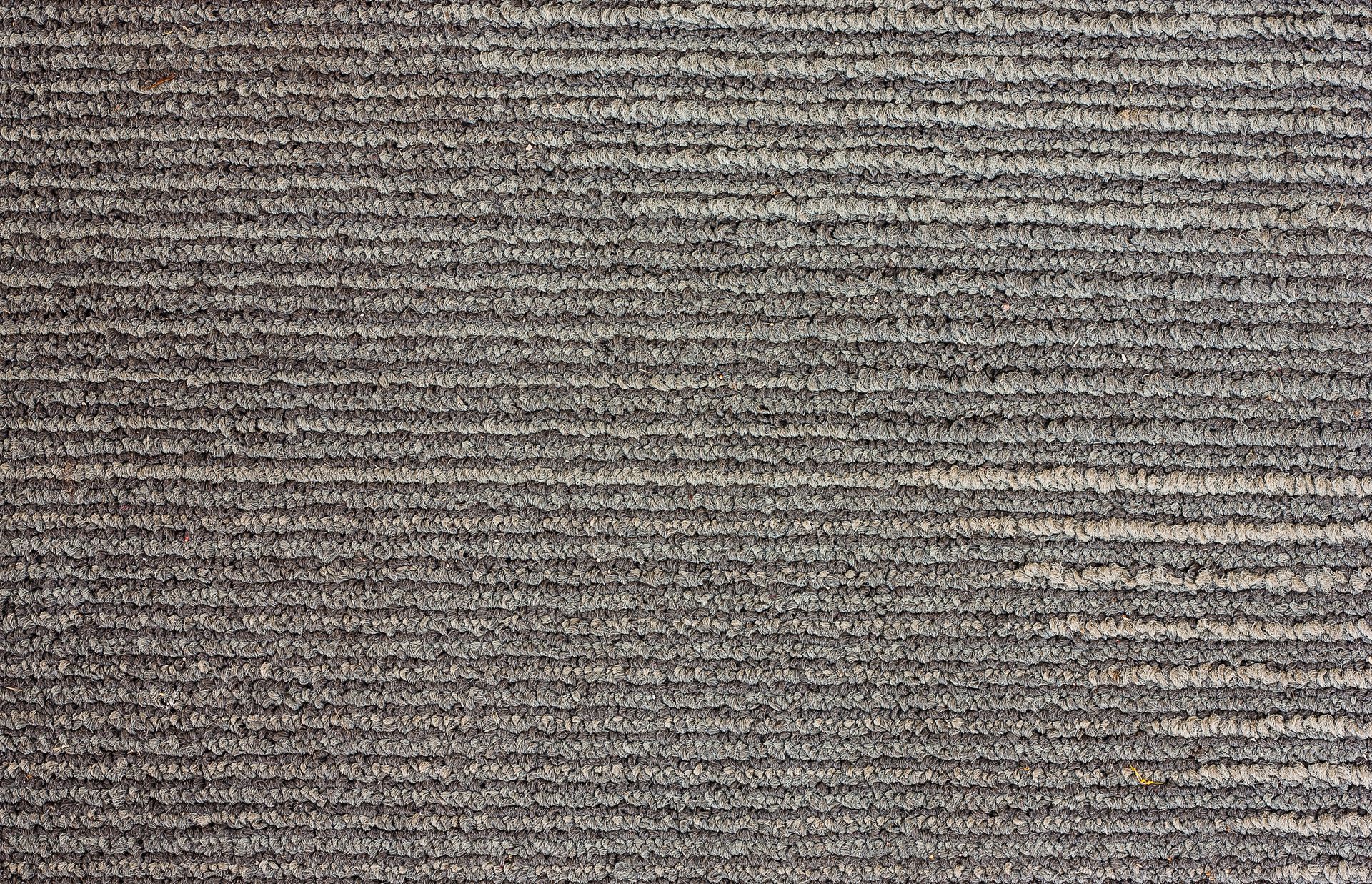 Close-up of a gray and tan striped carpet.