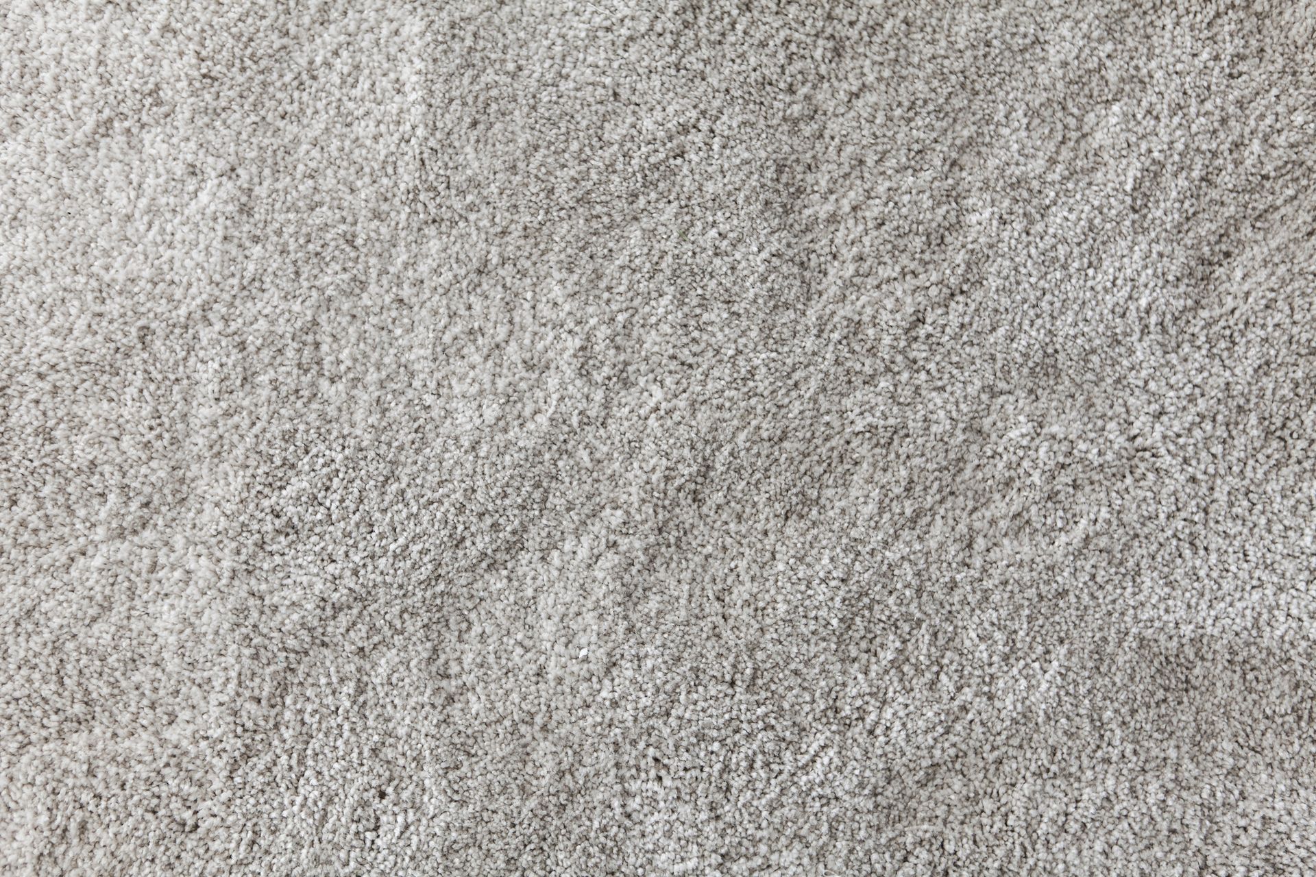 Close-up of a light gray, textured carpet with a plush, uneven surface.