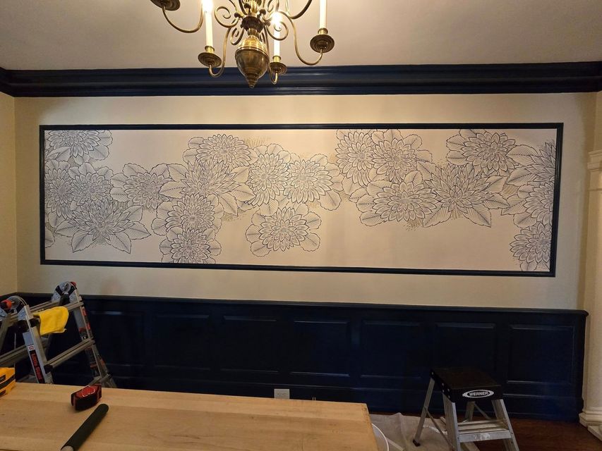 A large painting is hanging on a wall in a room.