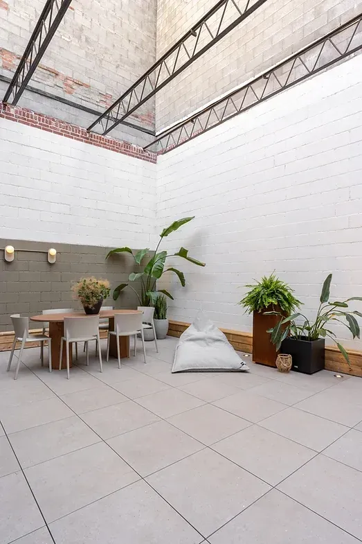 Une salle à manger avec une table et des chaises et un pouf.