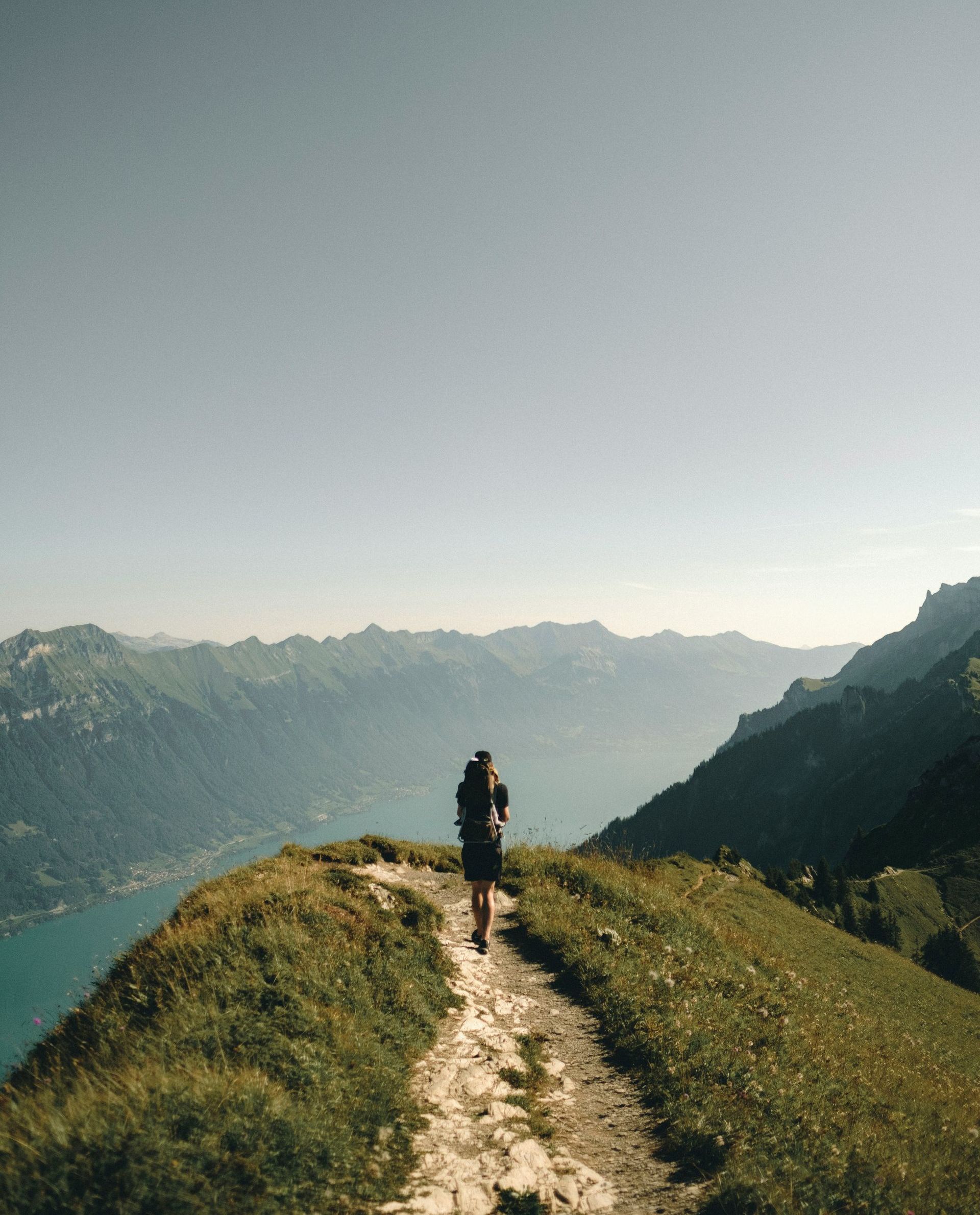A person is walking on a path in the mountains