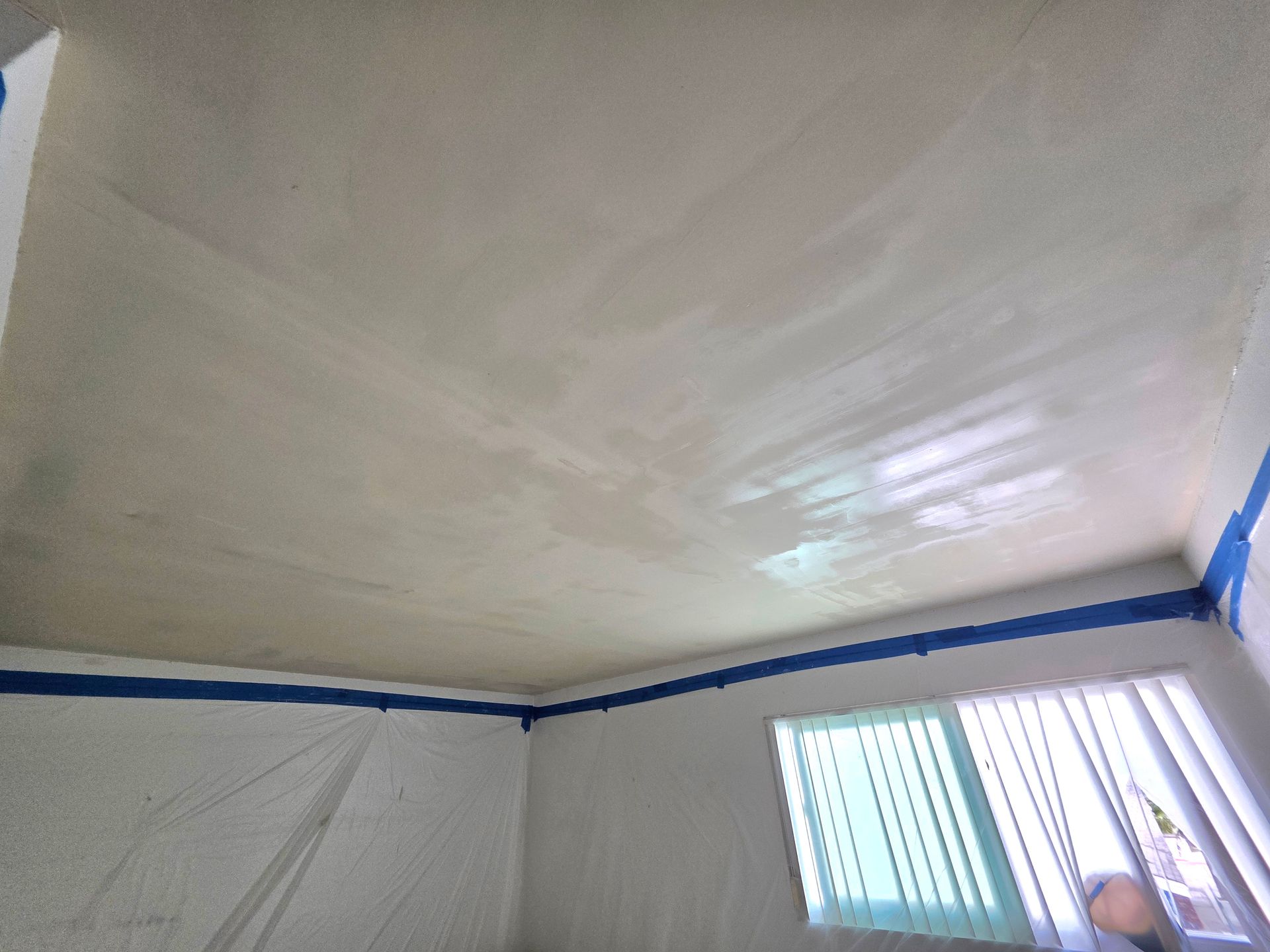 White tent interior with blue trim and a small window letting in daylight