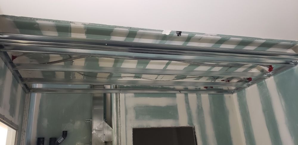 Metal ceiling frame with reflective panels in an unfinished room