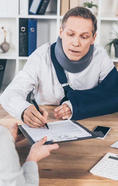 Man filling Out Forms At Workers' Compensation Section 32 Settlement Law Firm Ouimette, Goldstein, & Andrews, Servings Clients of the Hudson Valley for Over 45 Years