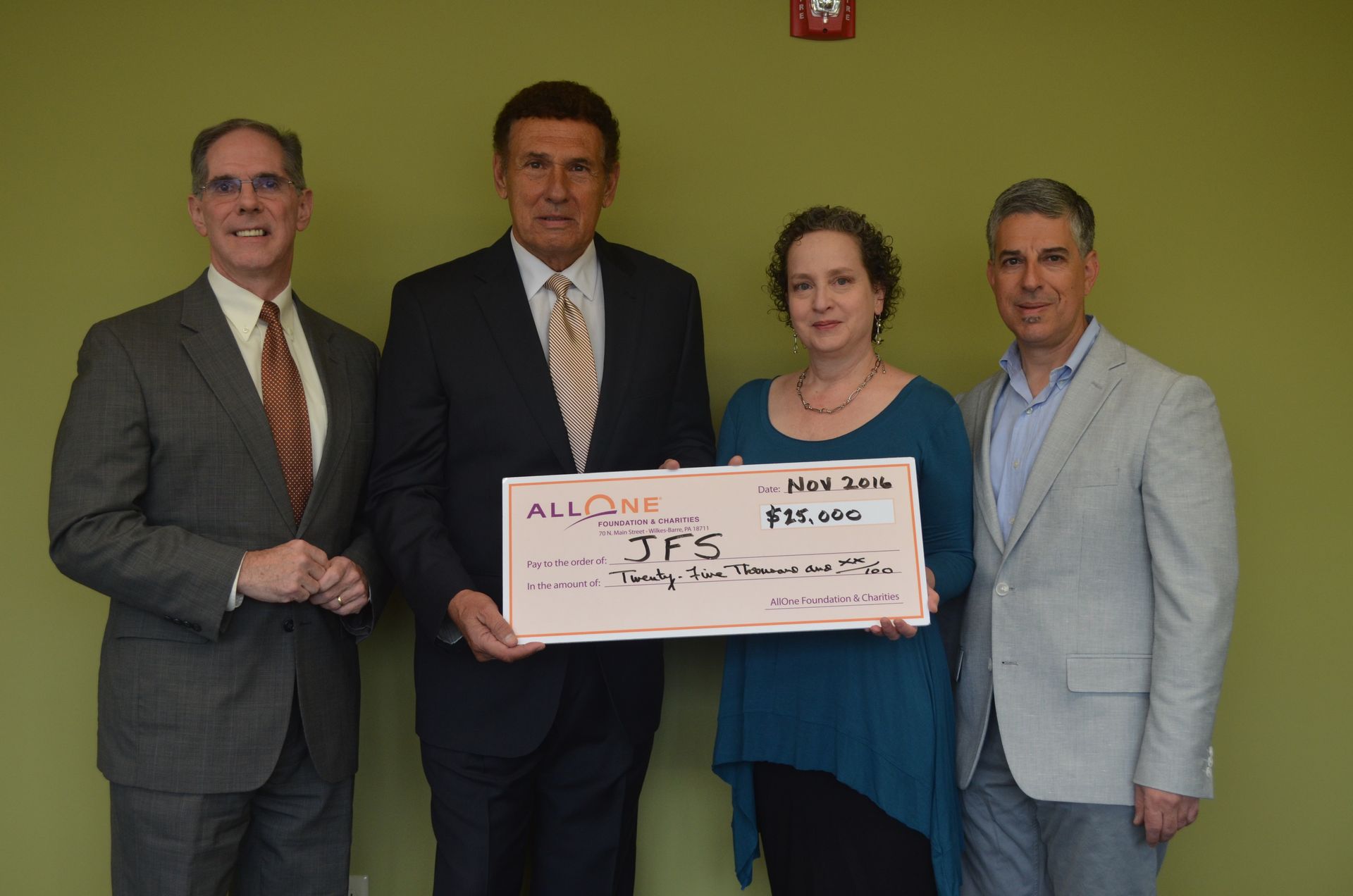 Four people holding a large check with the amount