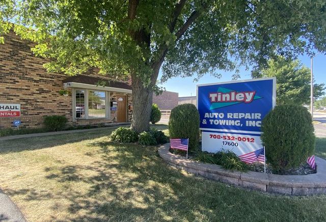 Tinley Auto Repair sign in front of a brick building on a sunny day | Tinley Auto Repair & Towing Inc