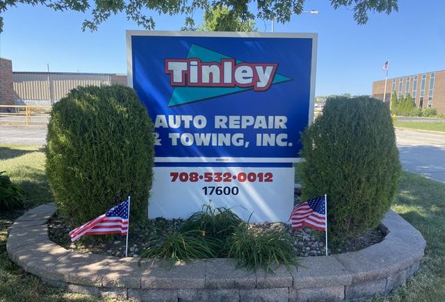 Tinley Auto Repair Towing, Inc. roadside sign with phone number and small American flags | Tinley Auto Repair & Towing Inc