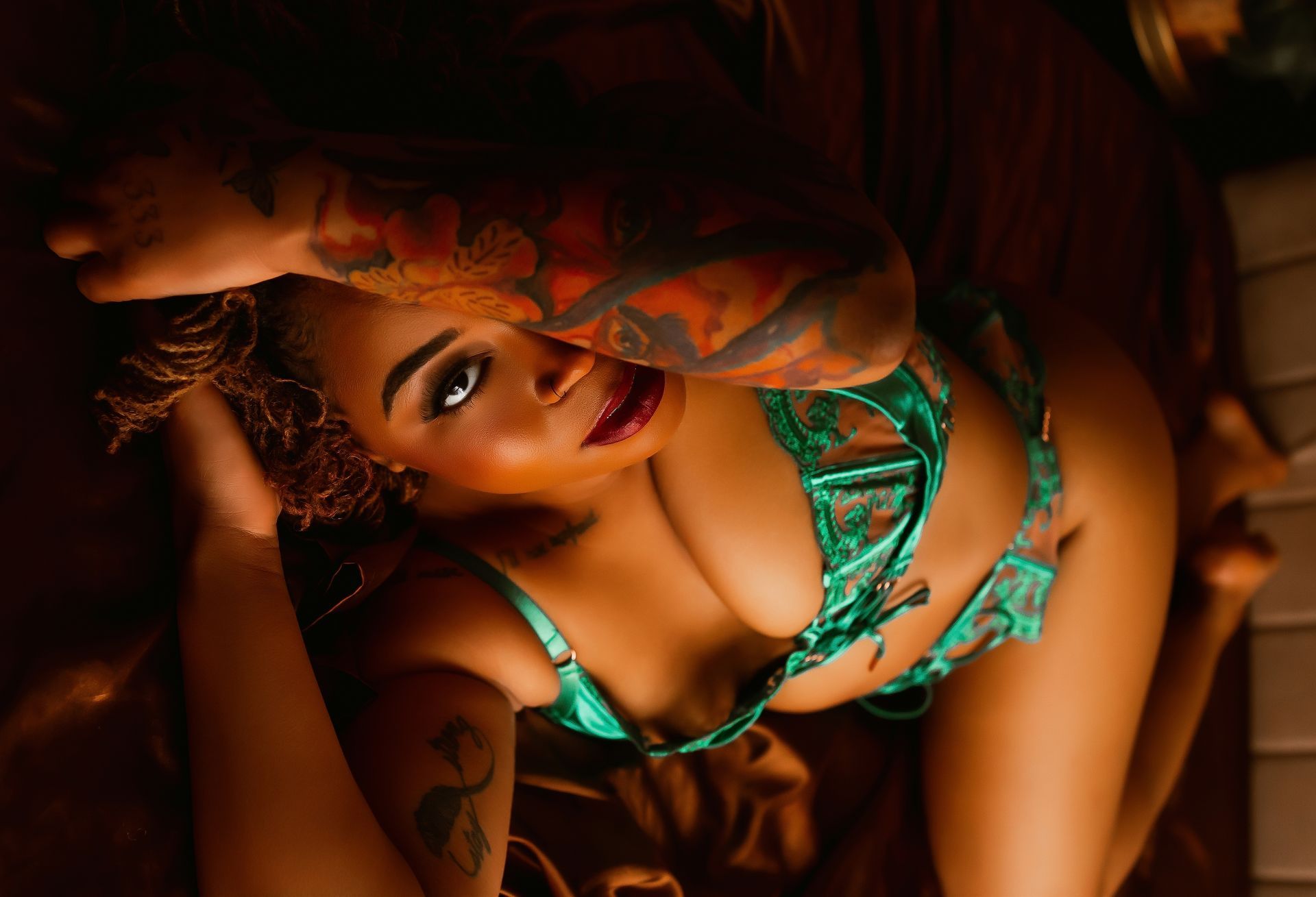 Woman in a green bikini posing with a warm, moody light and dramatic shadows