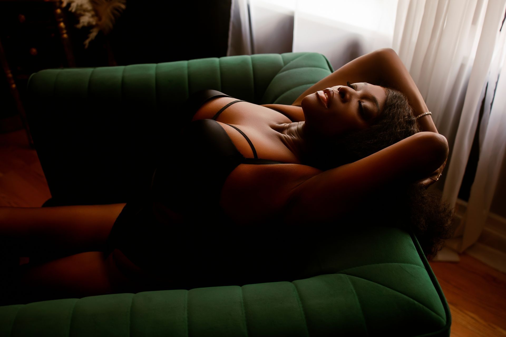 A woman in blue lingerie is laying on the floor in front of a mirror.
