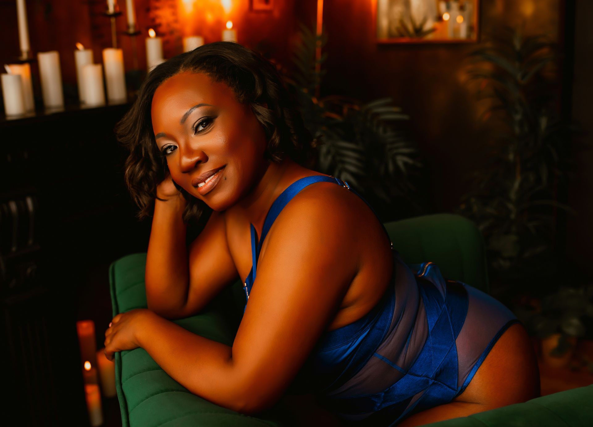 A woman in blue lingerie is laying on a green couch.