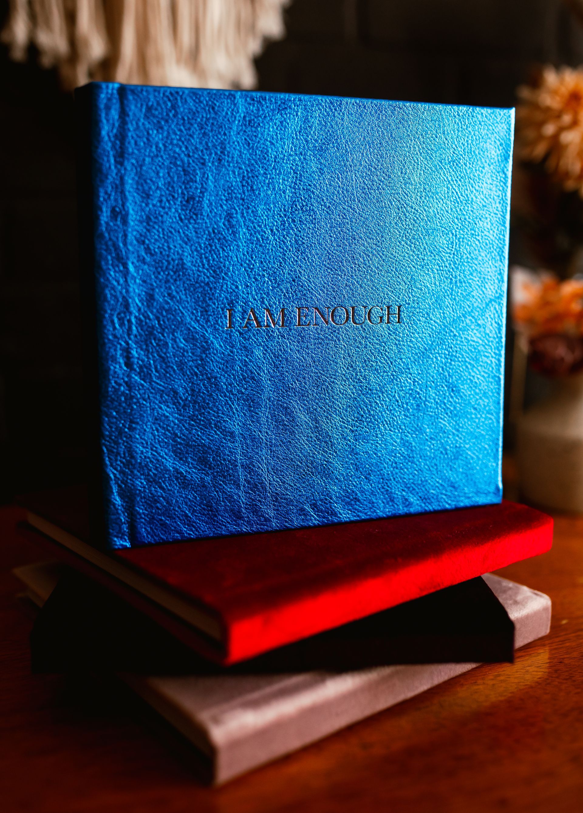 A blue box is sitting on top of a stack of books.