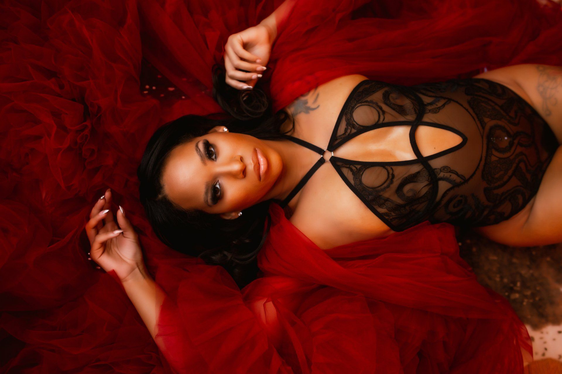 A woman in a black bodysuit and red robe is laying on the floor.