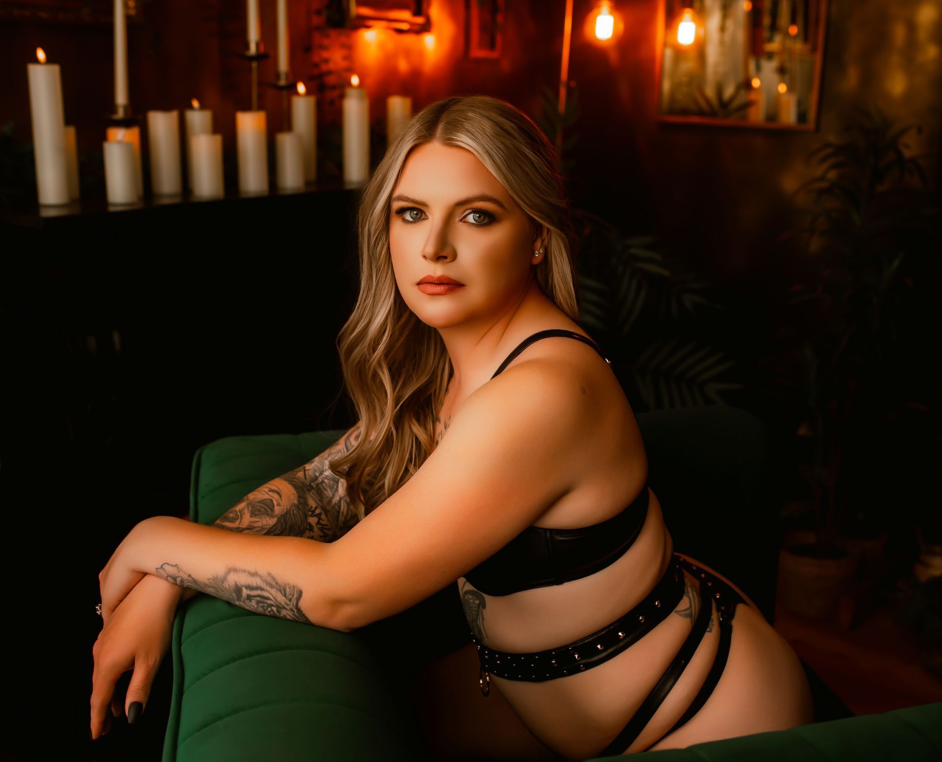 A woman in lingerie is sitting on a green couch.