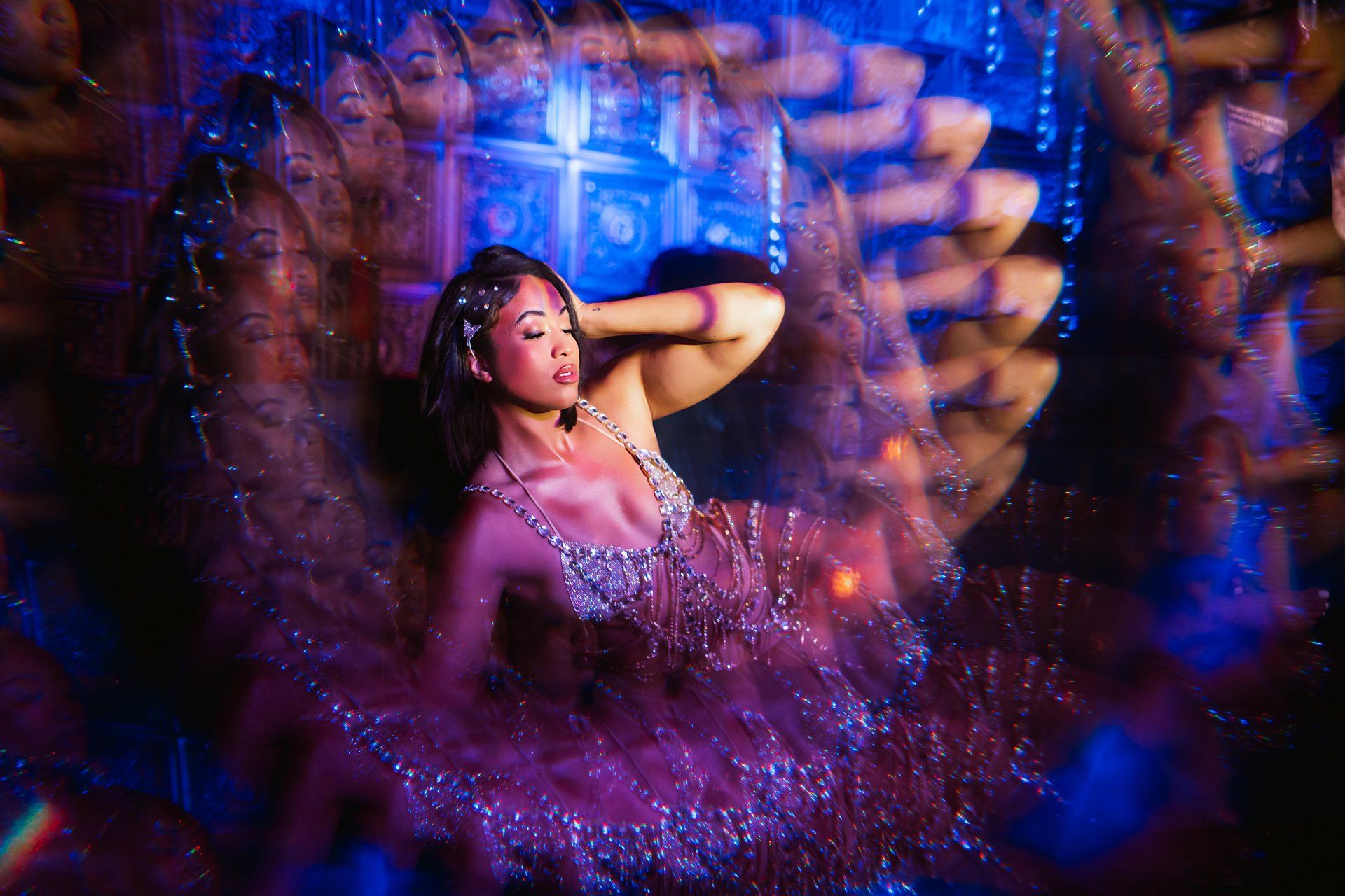 A woman in a purple dress is dancing in a dark room.
