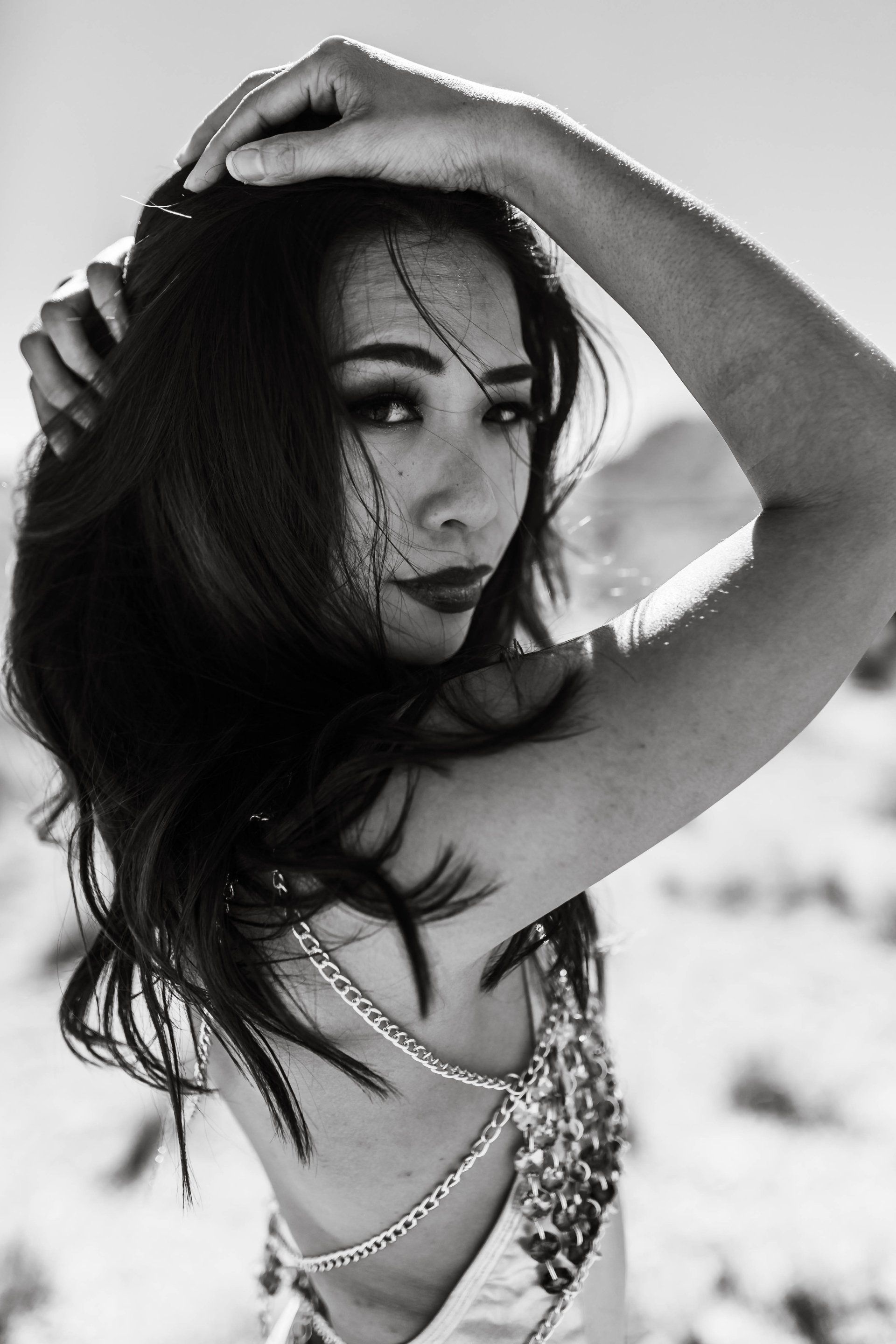 A black and white photo of a woman holding her hair.