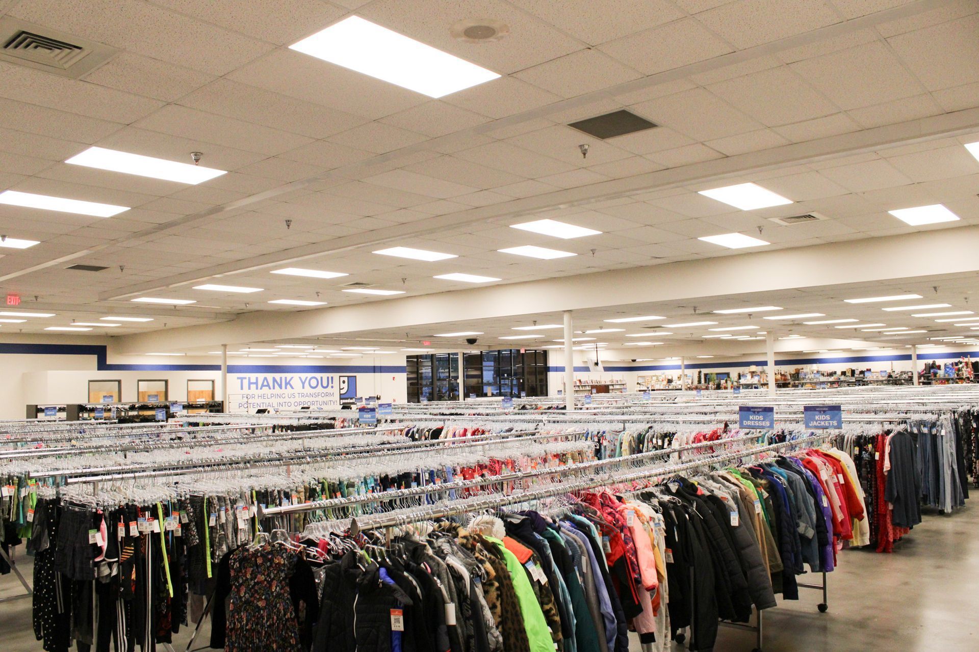 A large thrift store filled with lots of clothes on racks.