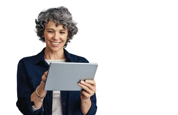 A woman is holding a tablet in her hands and smiling.
