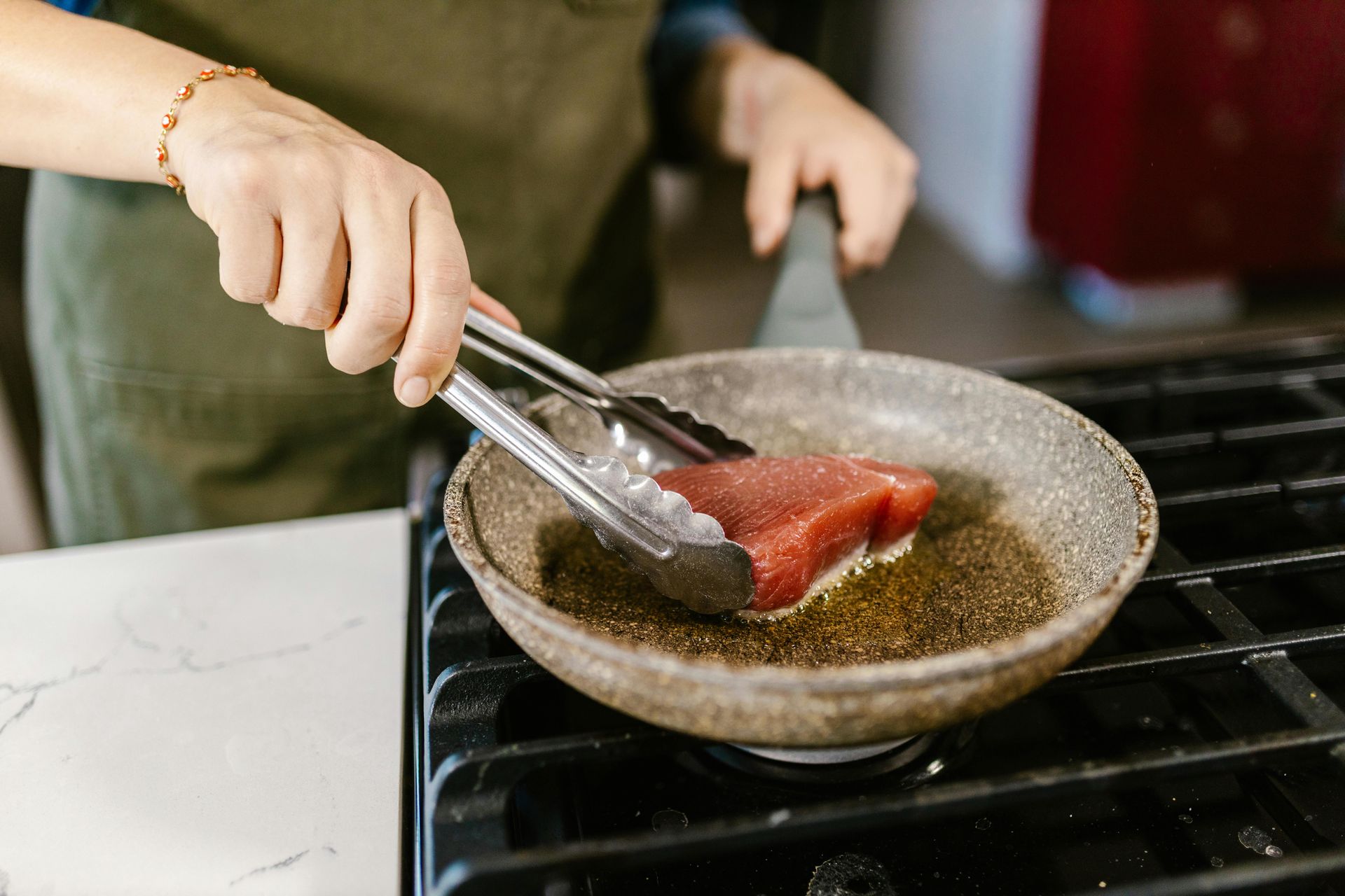 Two people cooking with fresh vegetables and herbs in a kitchen.