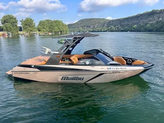 A boat is floating on top of a lake with mountains in the background.