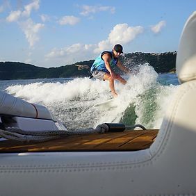 A man is riding a wave on a boat in the water.