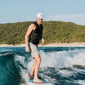 A man is riding a wave on a surfboard in the ocean.