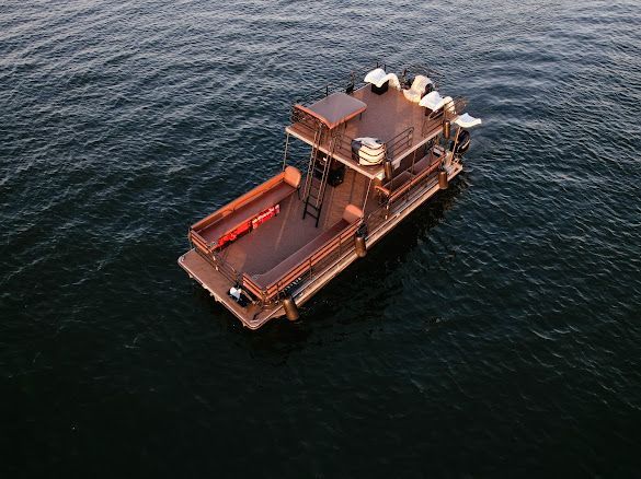 A red and white malibu boat is floating on a lake.