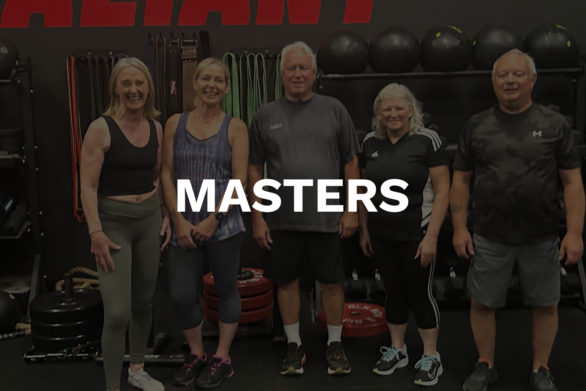 A group of people are standing in a line in a gym.