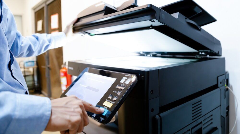 A Man Is Using A Tablet To Scan A Document From A Printer — Armidale Colour Copy Centre In Armidale, NSW