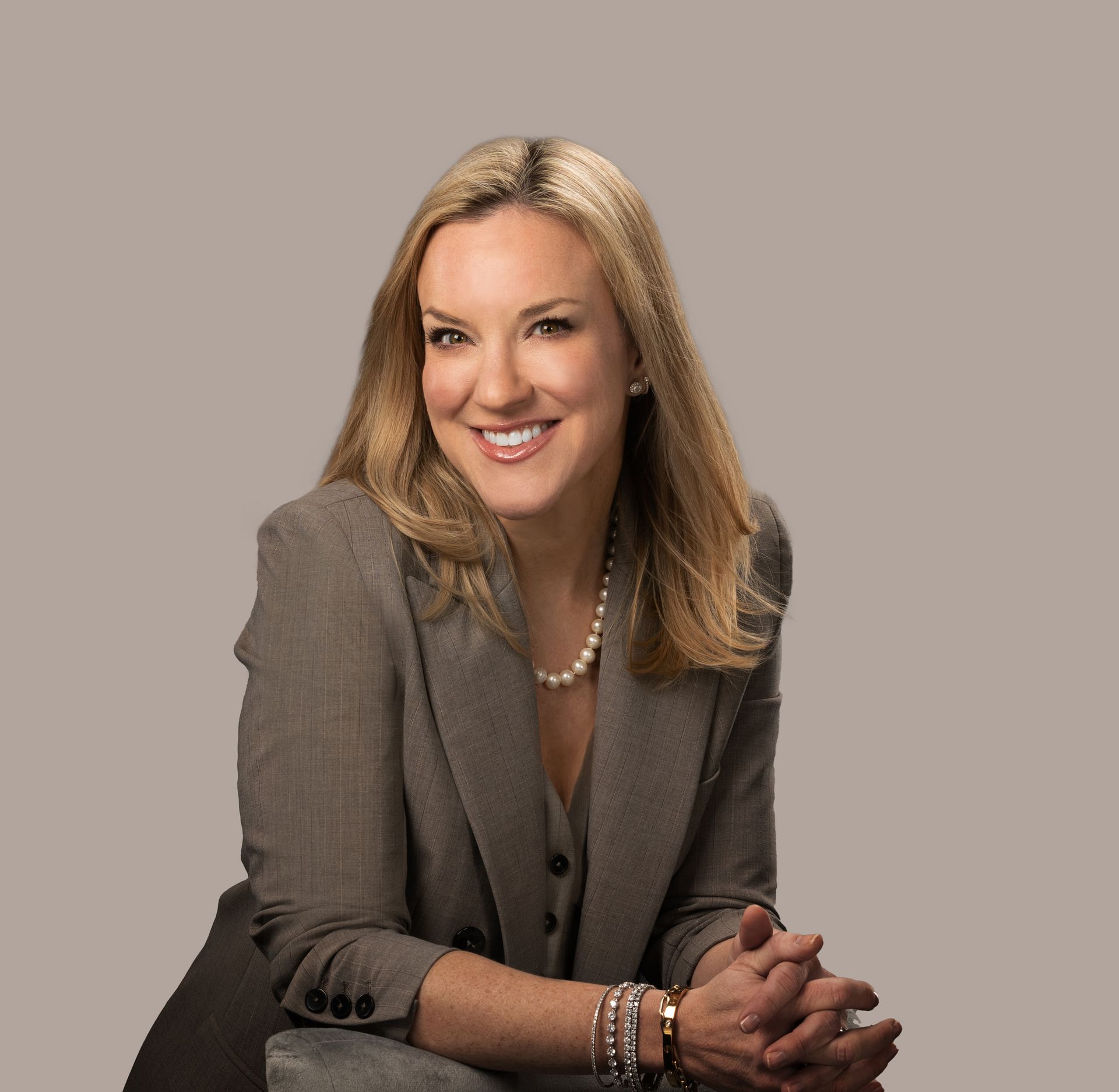 Mary Beth Olson (Founder of MBO Media) wearing a tan business outfit with pearl necklace