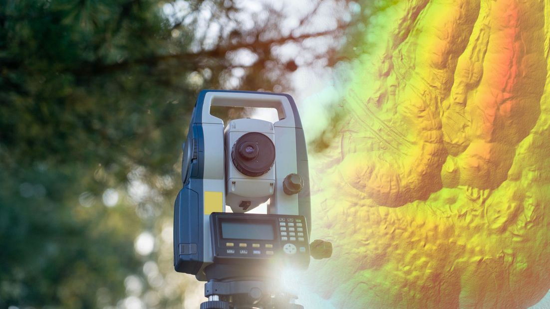Surveying instrument on a tripod outdoors, with a colorful elevation map overlay in the background