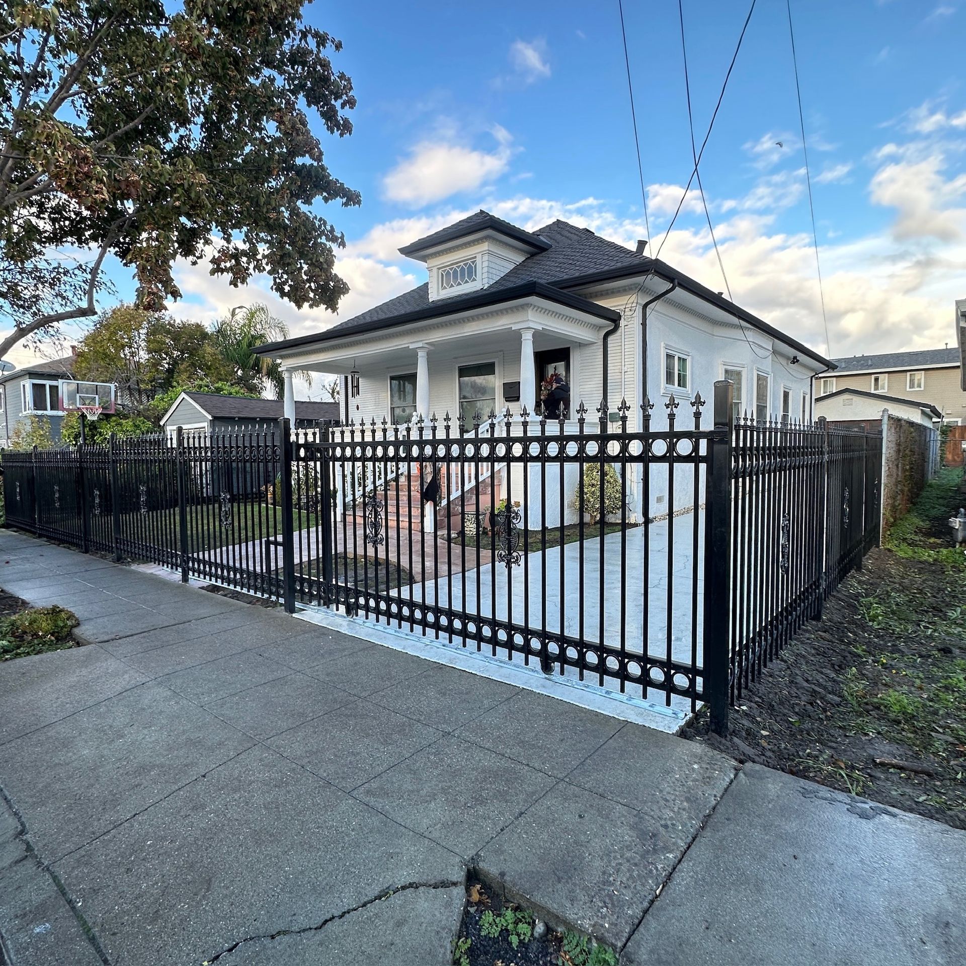 White house with black iron fence and sidewalk.