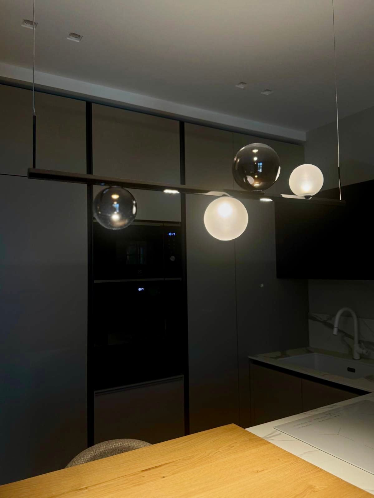 Cucina moderna con lampada a globo nera e argento appesa sopra il bancone.