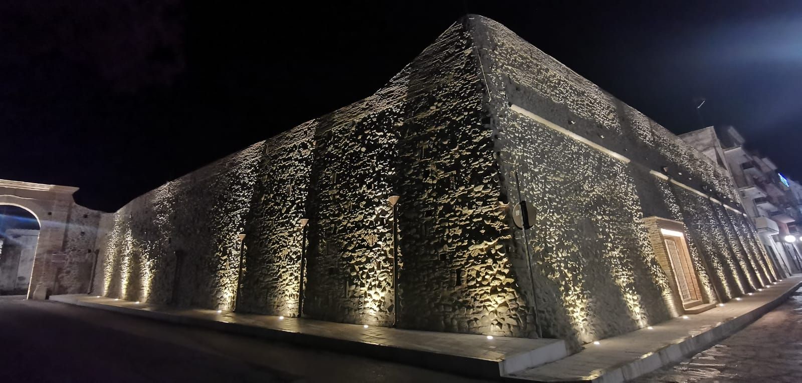 Un grande edificio in pietra illuminato di notte.