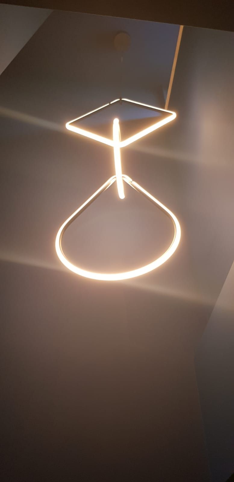 Lampadario geometrico illuminato appeso al soffitto.