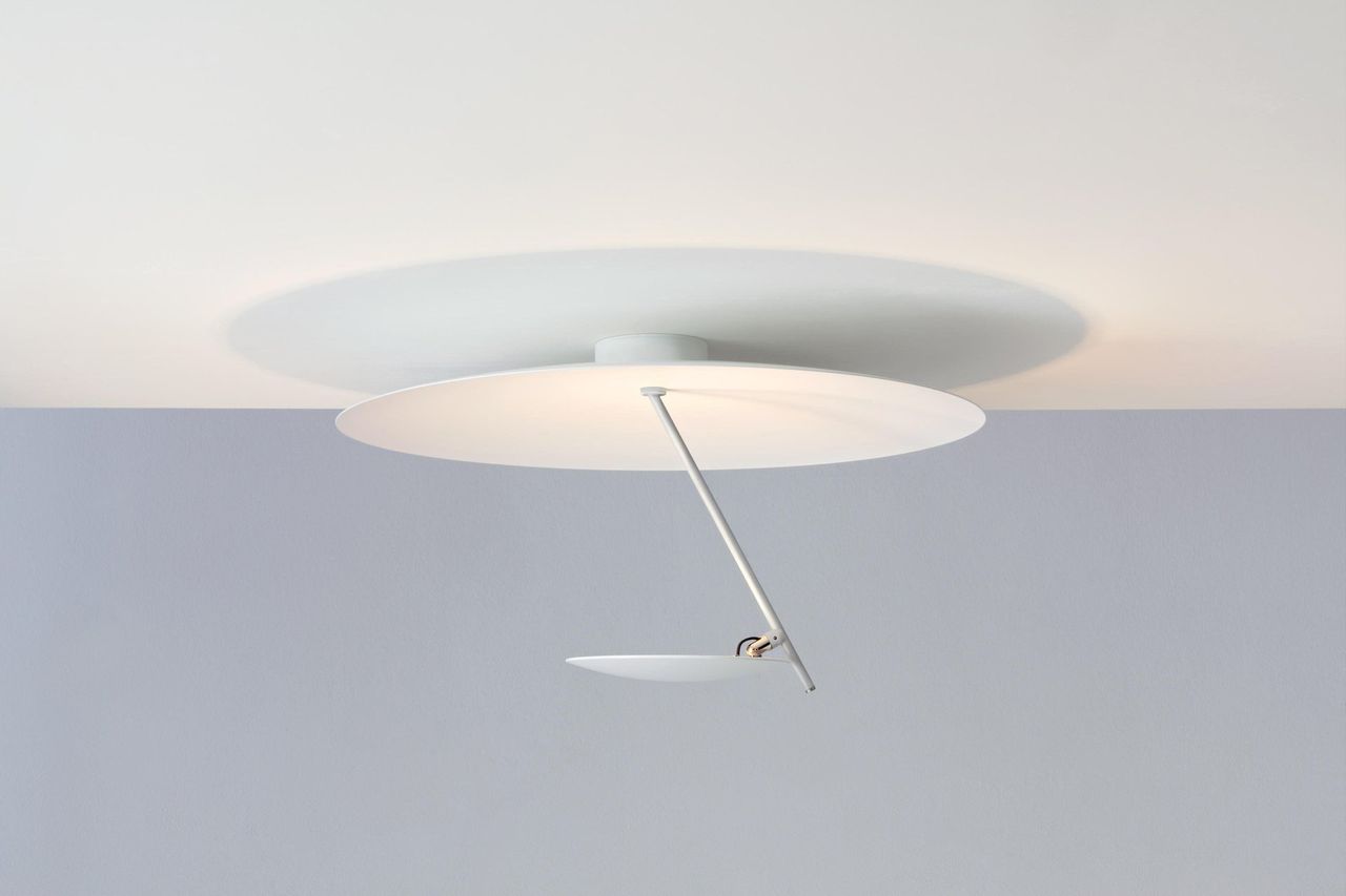 Lampada da soffitto bianca con due paralumi a forma di disco, uno sopra e uno sotto, con braccio regolabile e piccola lampada.