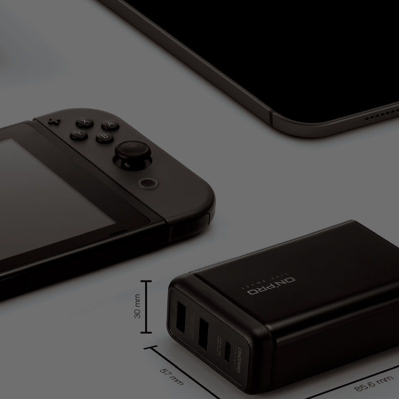 A nintendo switch next to a charger and a tablet
