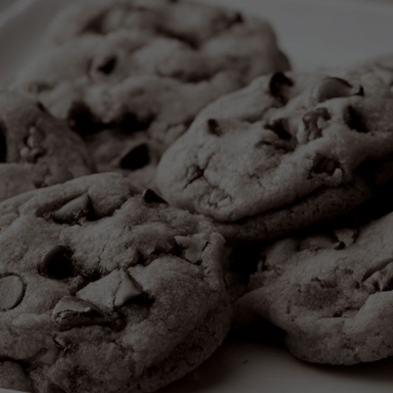 A black and white photo of chocolate chip cookies on a plate