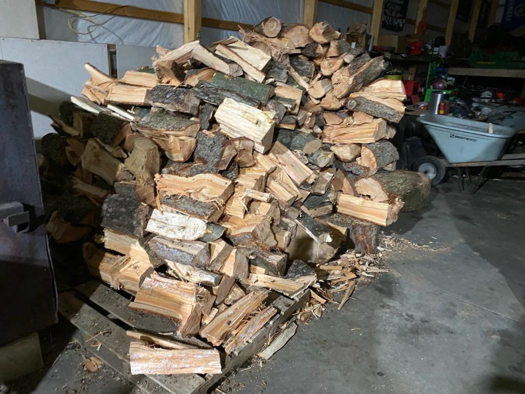 Pile of split firewood inside a building.