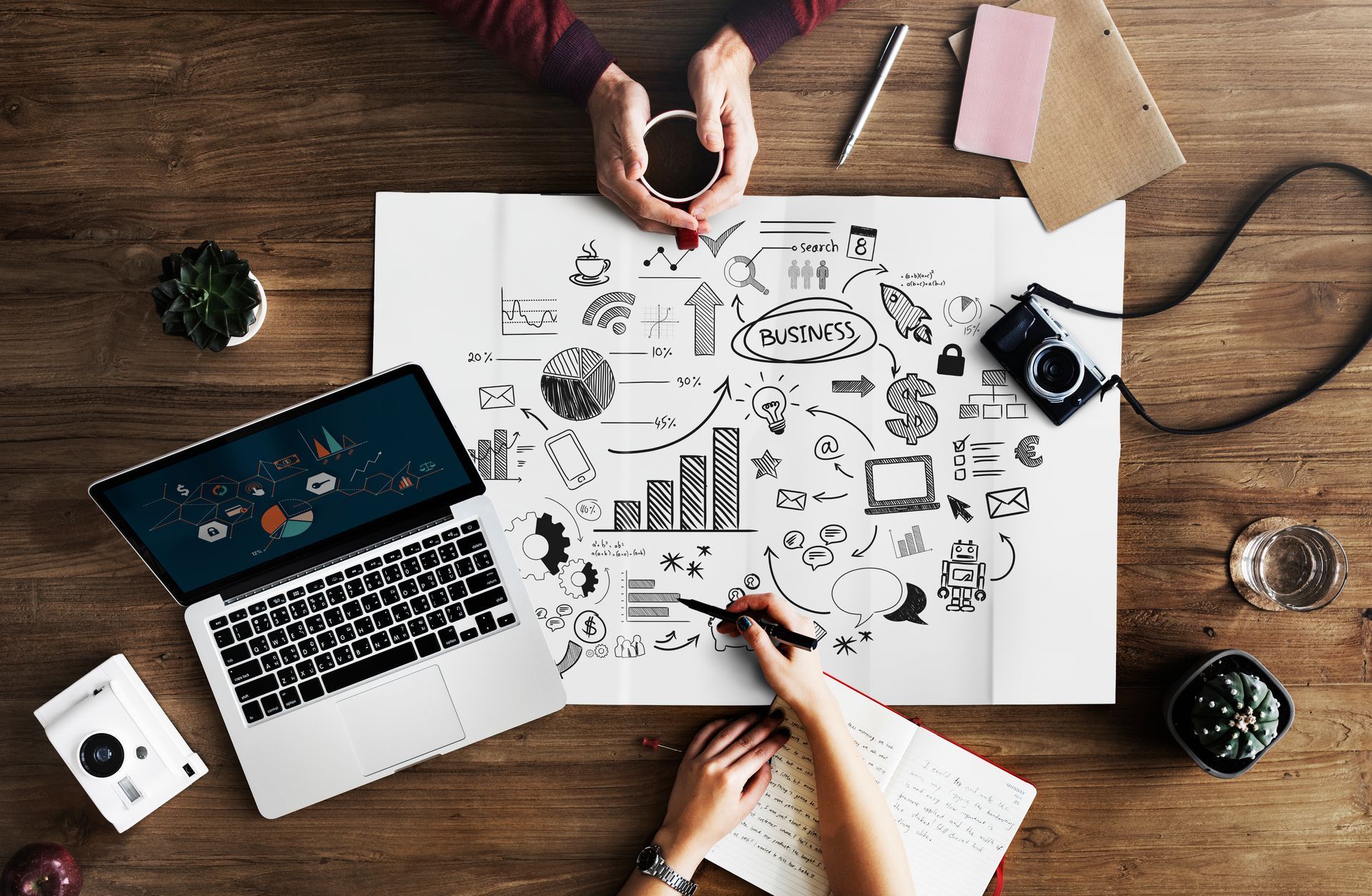 Une personne est assise à une table avec un ordinateur portable et un cahier.
