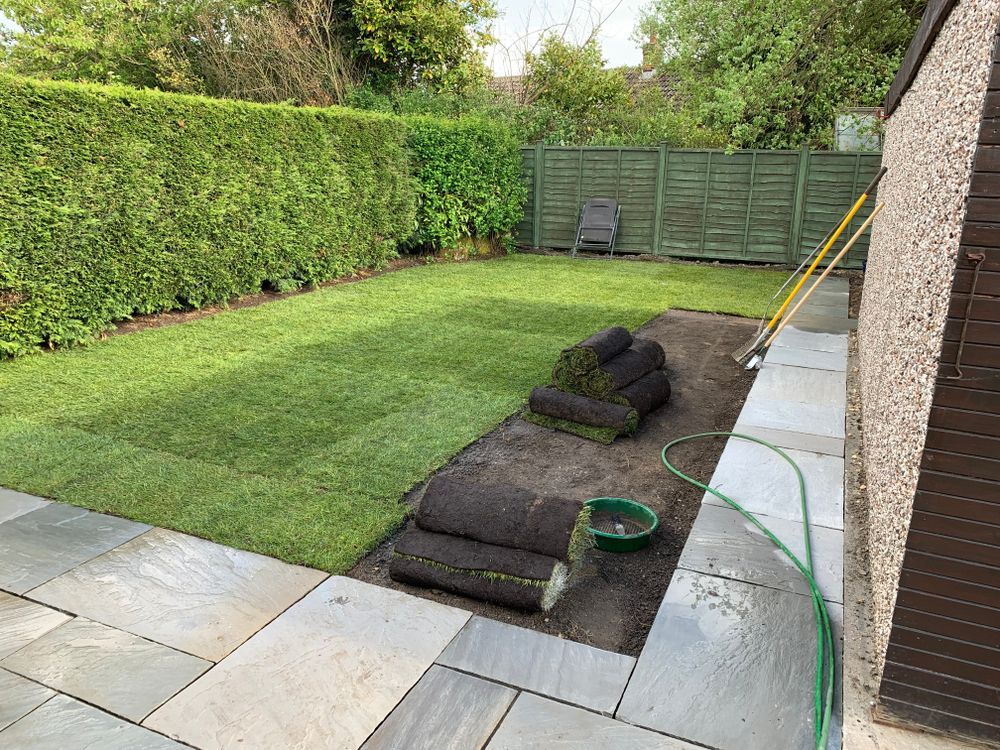 Newly Laid Grass Turf Rolls in A Residential Backyard with A Stone Patio — Ballina Turf Farm in Coraki, NSW