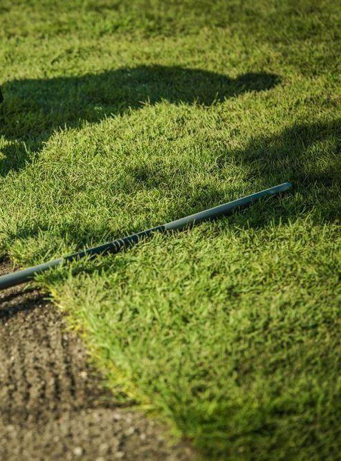 A Golf Club Lies on The Grass Near the Edge of A Sand Bunker — Ballina Turf Farm in Tweed Heads, NSW