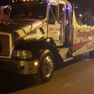 Tow truck decorated with colorful lights at night. 