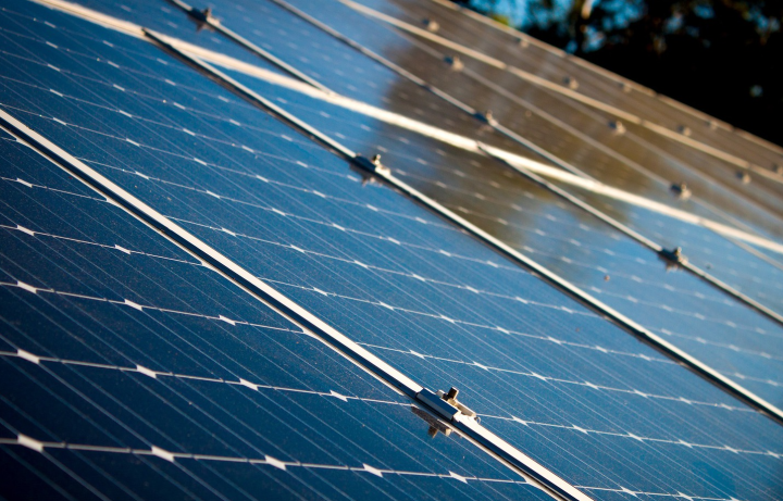 Paneles solares en un techo, celdas azules con soportes de metal, vista en ángulo.