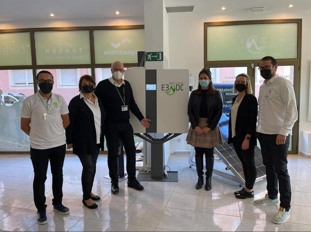 Grupo de personas de pie con una máquina en un interior moderno y luminoso.