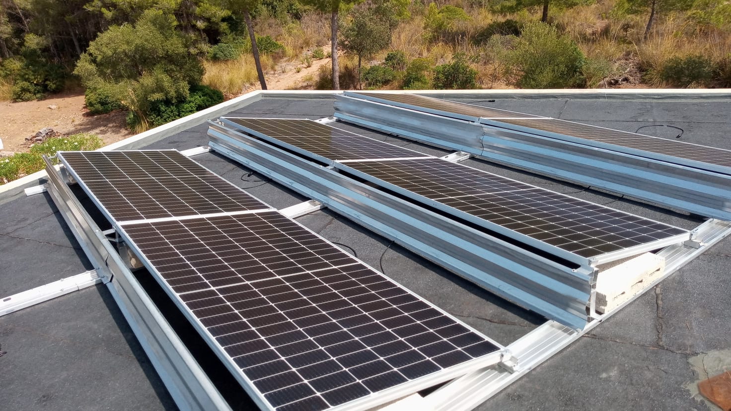 Paneles solares instalados en un techo plano, reflejando la luz solar.