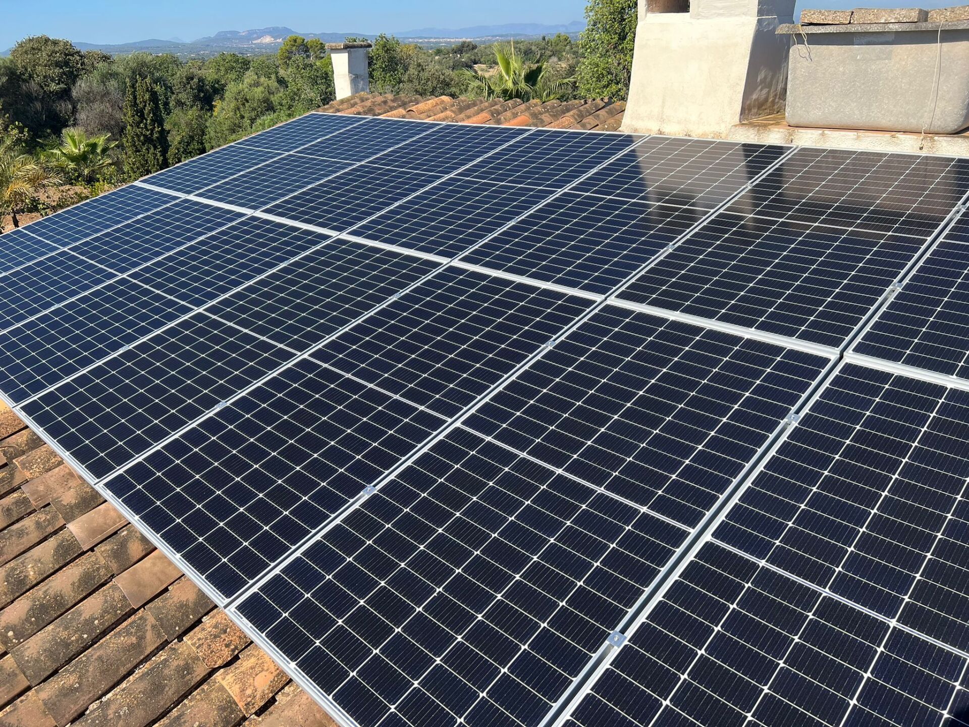 Paneles solares instalados en un tejado de tejas, día soleado.