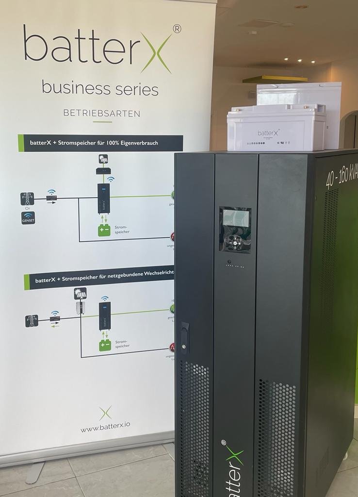Una unidad UPS de la serie empresarial BatterX negra con un diagrama de pancarta blanca en un entorno de oficina.