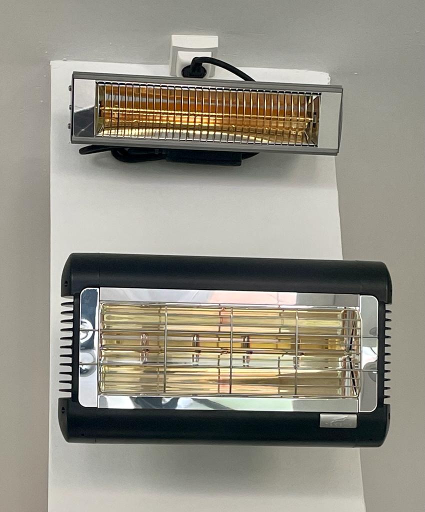 Two infrared heaters, one black, one silver, mounted on a white surface, showing heating elements.