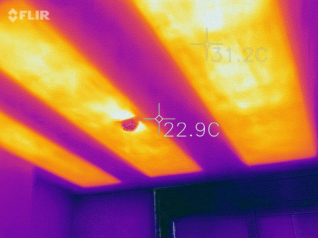Imagen térmica de un techo que muestra las zonas más cálidas (naranja/amarillo) y las más frías (morado). Se ve un ventilador.